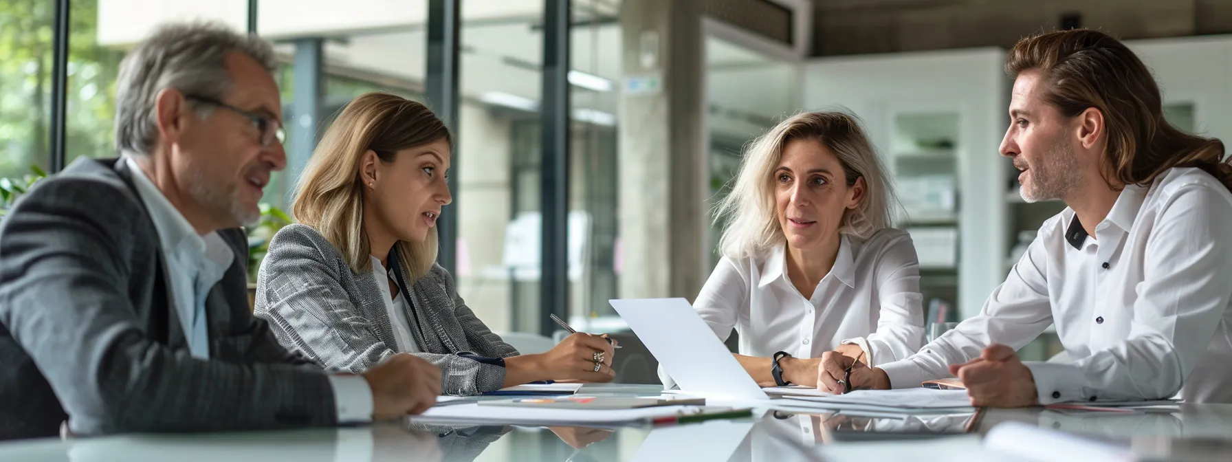 group of professionals analyzing documents and discussing senior care facility options around a table.