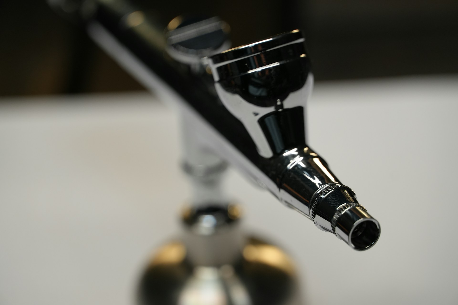 Close-up of a shiny chrome airbrush nozzle