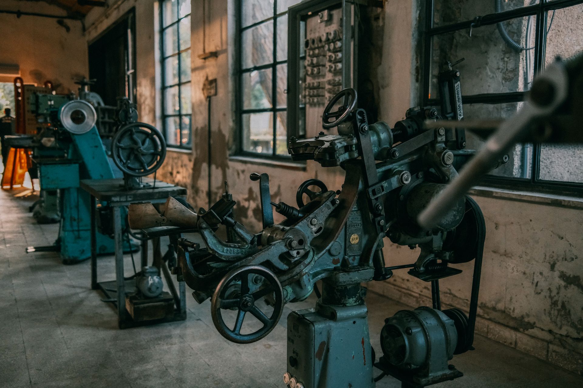 Old industrial machines in an abandoned workshop with vintage tools and equipment.