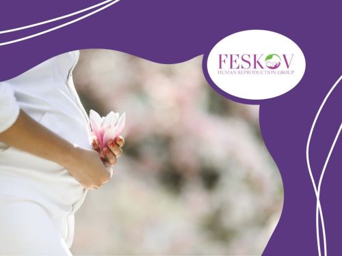 A pregnant woman in white clothing holding a flower, symbolizing fertility and motherhood.