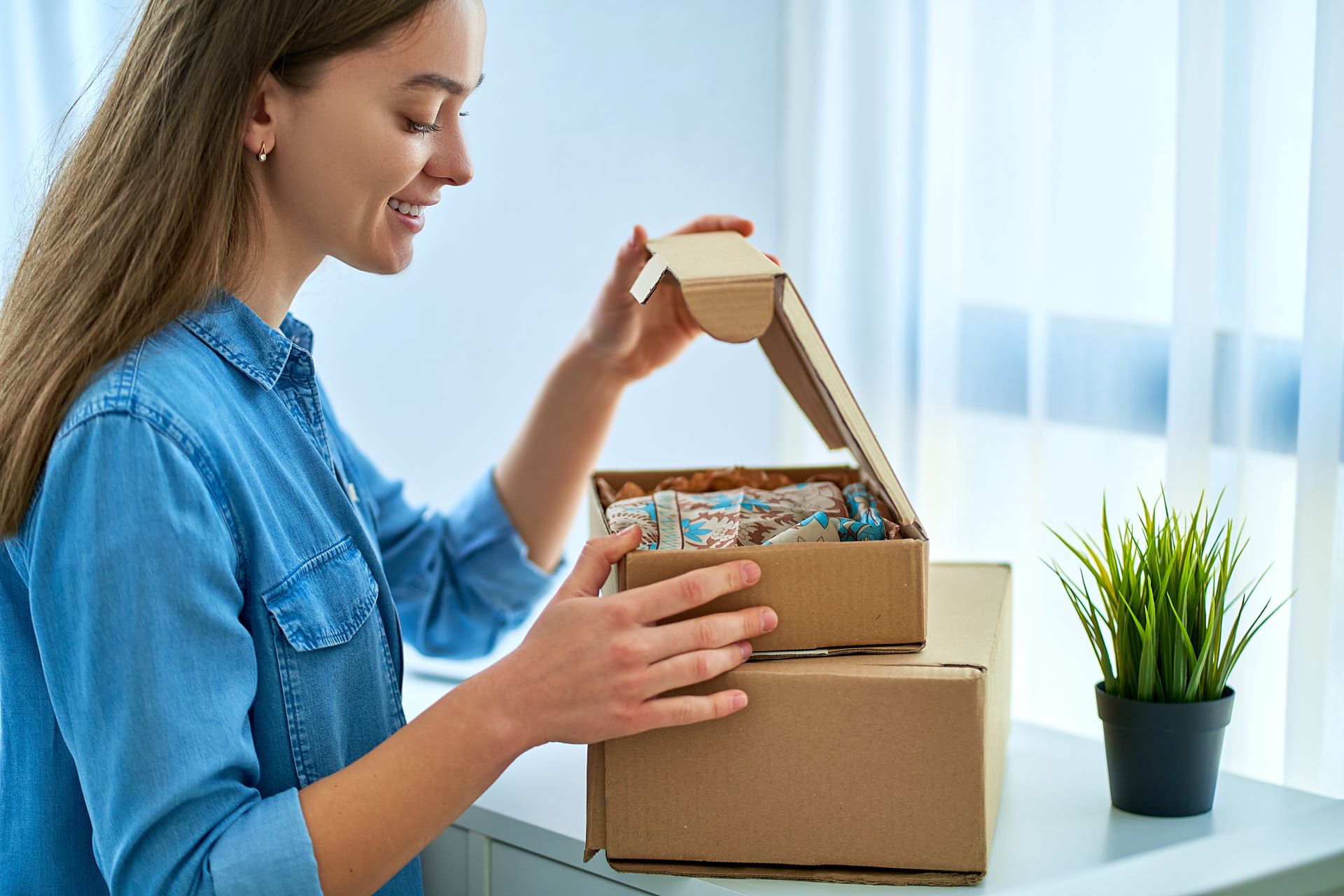 Woman in blue shirt opening a box
