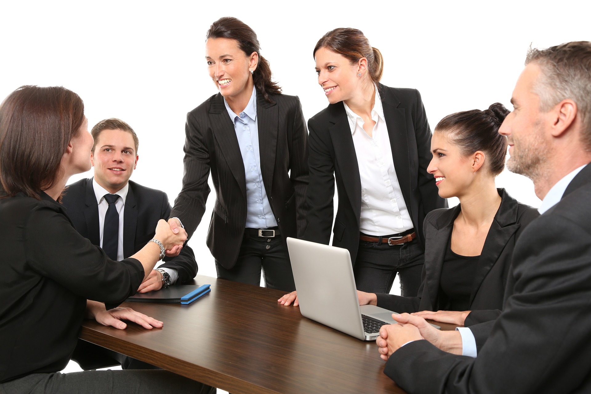 business people around a table shaking hands